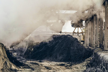 Overhead crane with mechanical multivalve clamshell grab and bucket excavator in the dusty of...