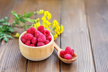 Tasty raspberry. Juicy berry. Summer. Wooden dishes. The concept is healthy food, diet, vegetarianism, vitamins.