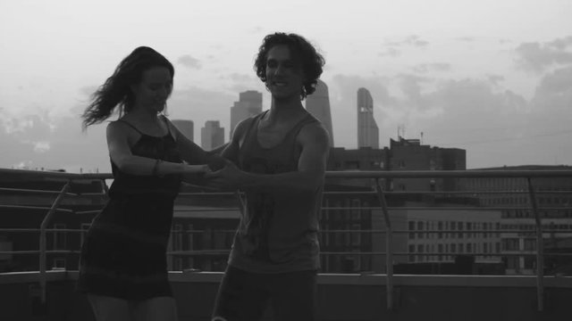 Silhouettes of young couple dancing on sunset