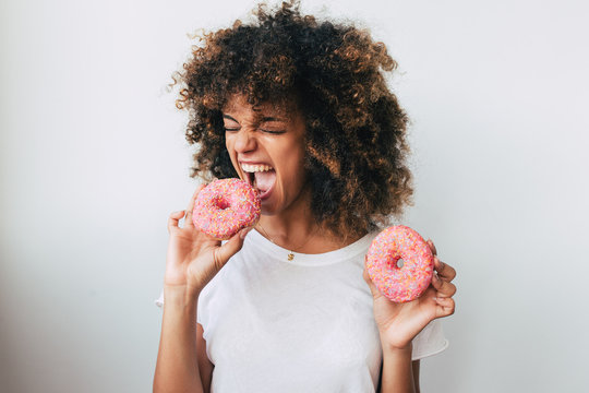 Afro young woman playing with donuts