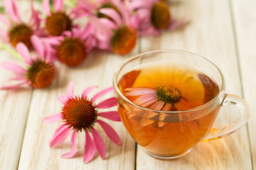 Cup of echinacea tea on white wooden table