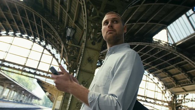 Man With Mobile Phone At Train Platform