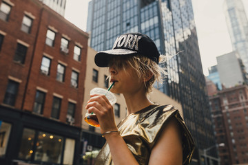 Bold Young Woman Walking on the Streets of Manhattan with a Golden Dress . New York City