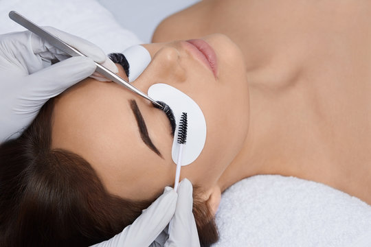 Eyelashes extensions. Fake Eyelashes. Eyelash Extension Procedure. Professional stylist lengthening female lashes. Master and a client in a beauty salon.