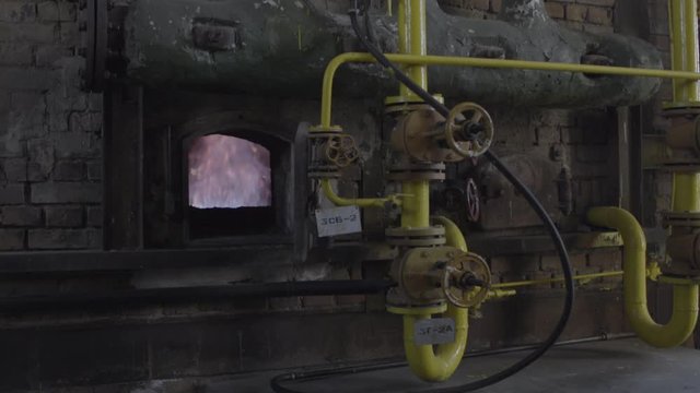Open iron stove in boiler room. Fire inside the furnace at the plant