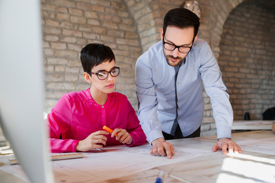 Portrait of two architects looking at project scheme