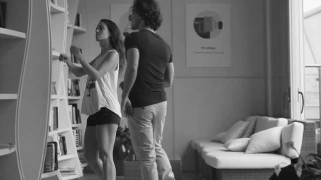 Woman getting up from sofa and taking a book