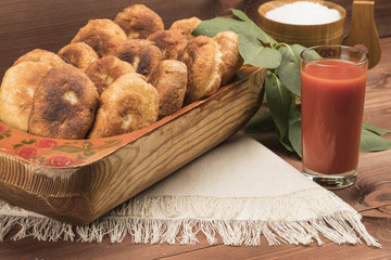 Rustic hot patty in a plate on a table with tomato juice and a napkin
