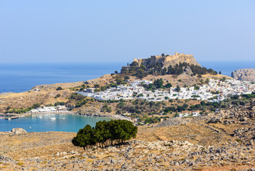 Panoramic view on Lindos town with a beautiful lagoon and ancient fortress on a hill at Rhodes island, Greece