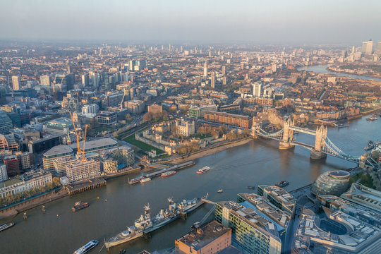 a view of Thames river and London at sunset with red sky and air pollution with Tower bridge