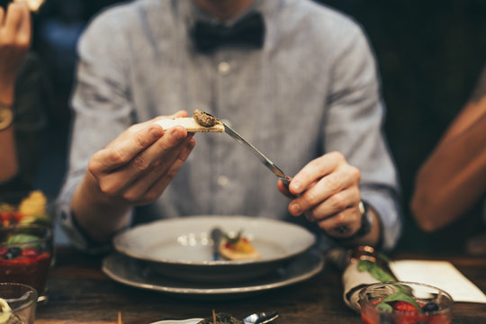Man Putting Sauce on Piece of Bread