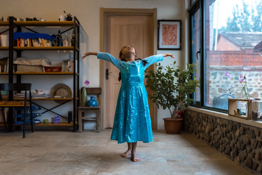 Young girl in party dress dancing at home