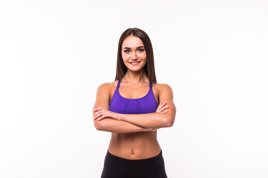 Smiling sports woman standing with arms folded and looking at camera isolated on a white background