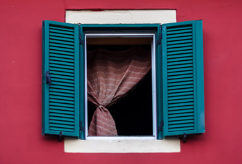 Fototapeta na wymiar Green window on a red building