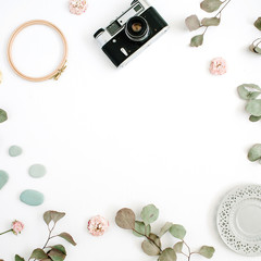 Flat lay border frame with retro camera, eucalyptus branches, plate on white background. Top view artist background with space for text.