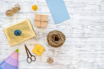 Preparing to celebration. Colored gift boxes and party hats on grey wooden background top view copyspace