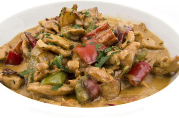 curry sauce on the plate of chicken with vegetables on a white background