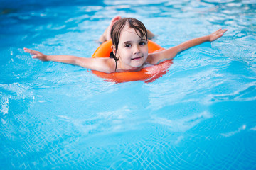 Little girl in swimming pool with float ring