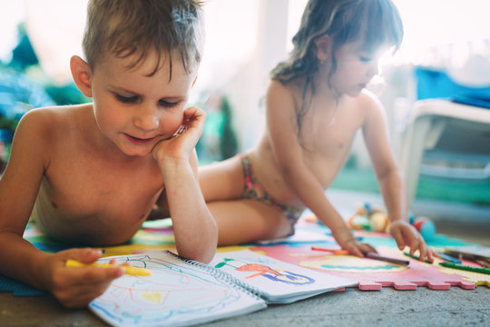 Little boy and girl drawing with crayons