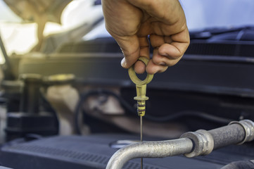 Auto mechanic uses hand of technician checking or fixing engine of in a car.