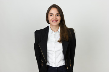 Portrait of a pretty young businesswoman standing over gray background