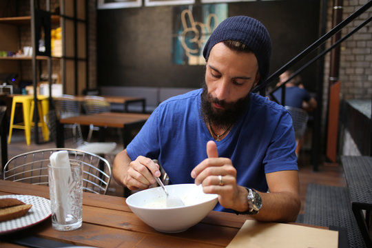 Bearded man eating soup