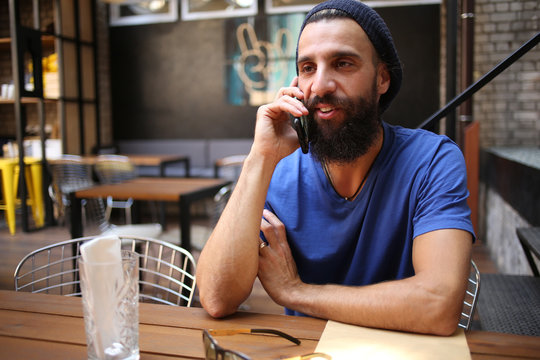 Bearded hipster talking on phone