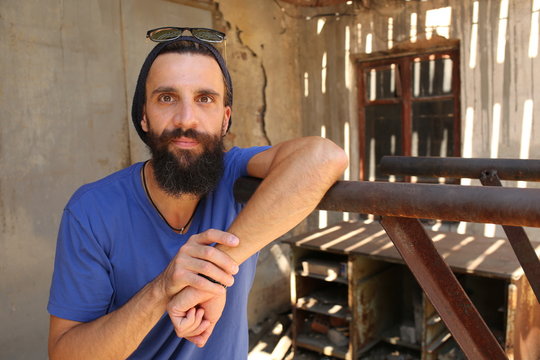Bearded man standing near the parallel bars