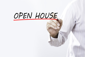 Businessman hand writing OPEN HOUSE with red marker on transparent wipe board, business concept