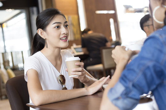 Asian Woman Drink Coffee at Cafe with Attractive Smiling Together, Woman Talking with Friend while Drink Coffee, Woman Lifestyle Concept.