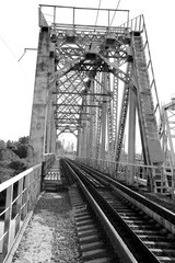Railway metal bridge perspective view. Steel rail track. Black and white image