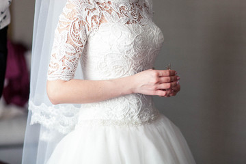 Fototapeta na wymiar Beautifully folded hands of the bride on the dress