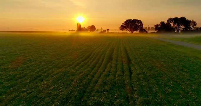 Ethereal, beautiful sunrise over foggy agricultural landscape, aerial perspective.
