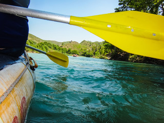 Paddle, river and the side of the boat during rafting
