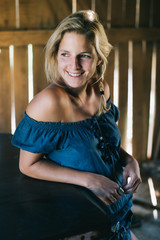 Farmer woman smiling in a barn. Farm life concept.