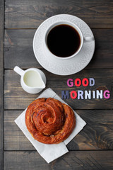 Cup of coffee and wood letters GOOD MORNING on wooden table background. Top view, copy space. Concept breakfast