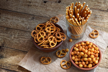 Salty snacks. Crackers, pretzel, salted straws, nuts. Junk food for beer or cola. Photographed with natural light.