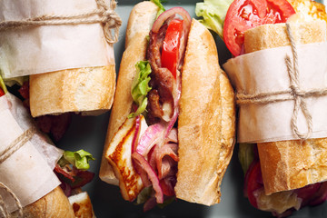 Fresh baguette sandwich bahn-mi styled. Bacon, roasted cheese, tomatoes and lettuce on metallic...