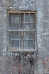 exterior view of old wall with closed glass window.