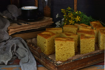 Homemade corn cake with tangerines on dark background. Traditional Brazilian sweet pie. Cornbread. Style Dark Moody