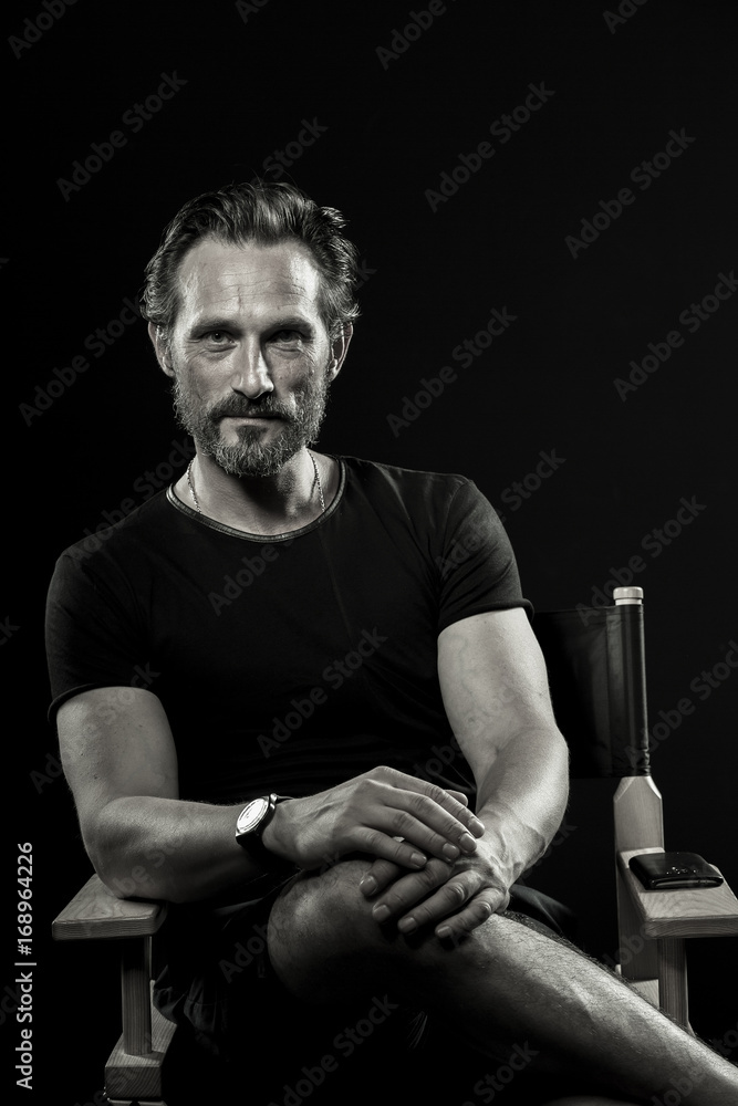 Wall mural black and white portrait of strong mature man. beardy male showing satisfied emotion.