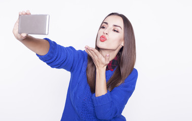 Naklejka premium Woman with a smartphone makes selfie isalated on white.