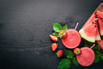 Fresh cocktail of watermelon and strawberries. Mint, ice. On a wooden board. Top view. Free space for your text.