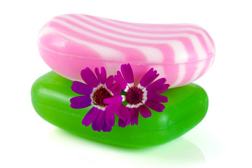 Two multi-colored striped soaps with a flower isolated on white background