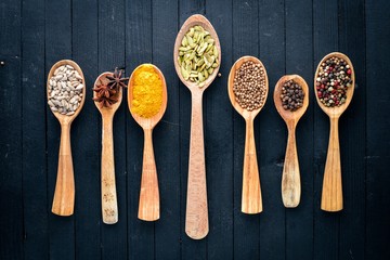 Various spices spoons on stone table. On a wooden board. Top view. Free space for your text.