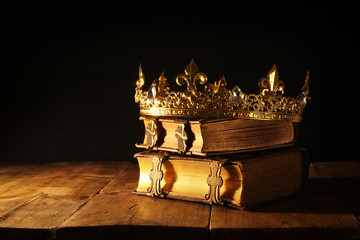 low key of beautiful queen/king crown on old books. vintage filtered. fantasy medieval period