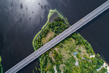 Aerial view of the bridge and the road over the Dnepr River over a green island in the middle of...