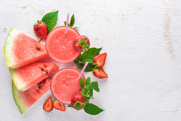 Fresh cocktail of watermelon and strawberries. Mint, ice. On a wooden board. Top view. Free space for your text.