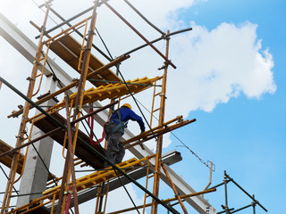 Construction workers working on scaffolding, Man Working on the Working at height with blue sky at construction site