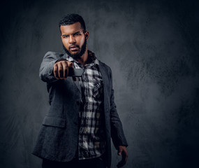 Black hipster male dressed in a fleece shirt and a jacket.